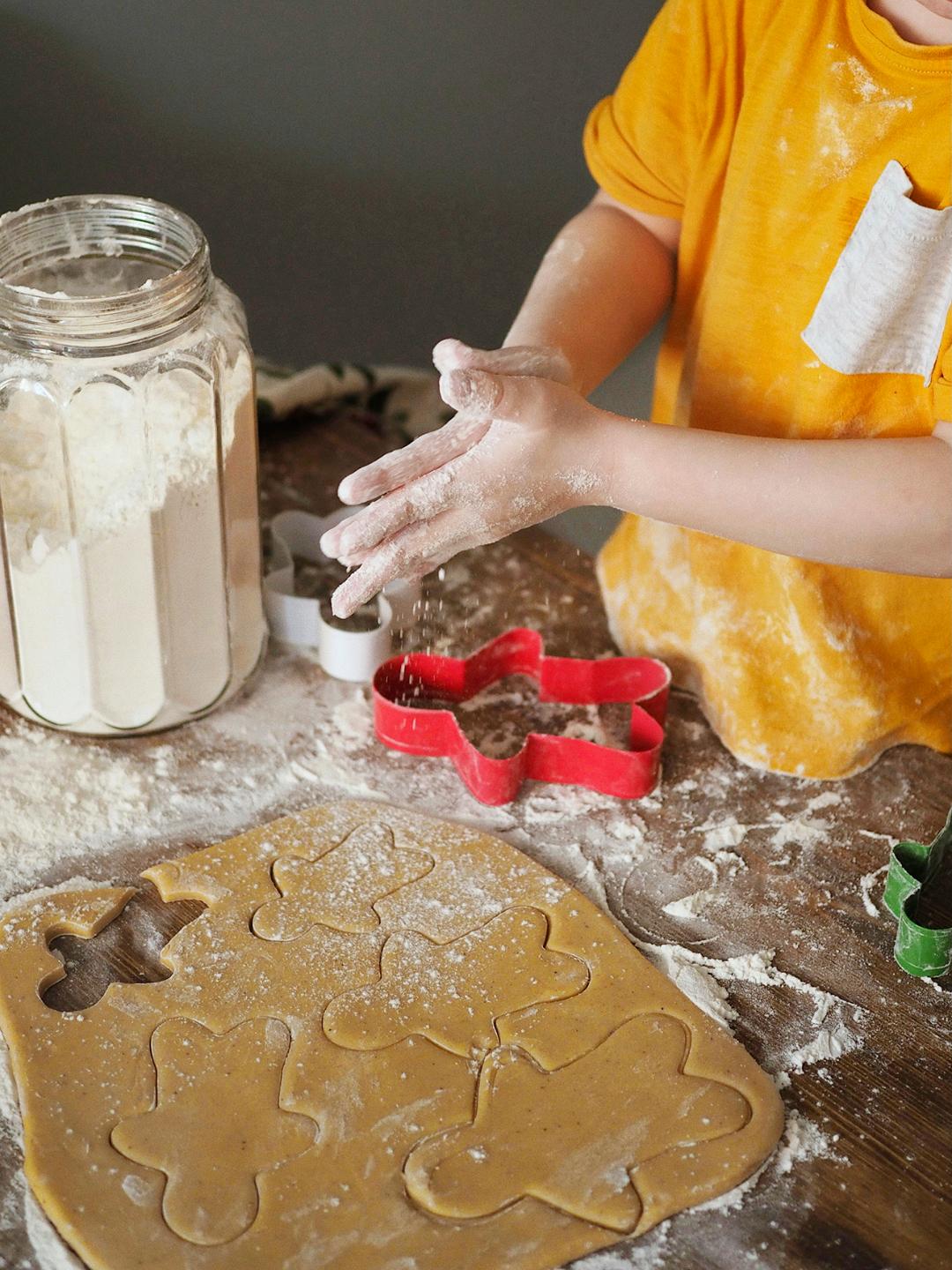 Barnhänder som bakar pepparkakor